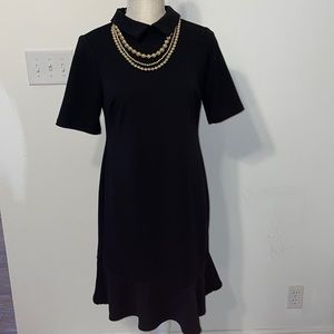 Shelby & Palmer black dress with gold necklace